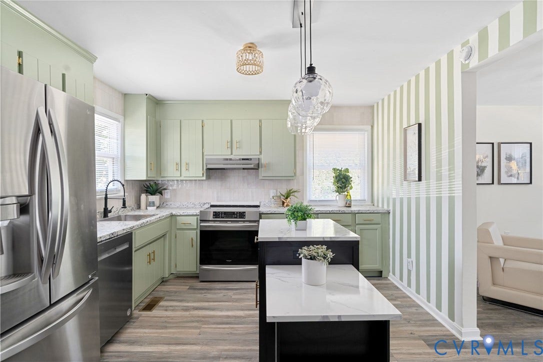 Kitchen with light green cabinetry, white countertops, and wood-finish flooring