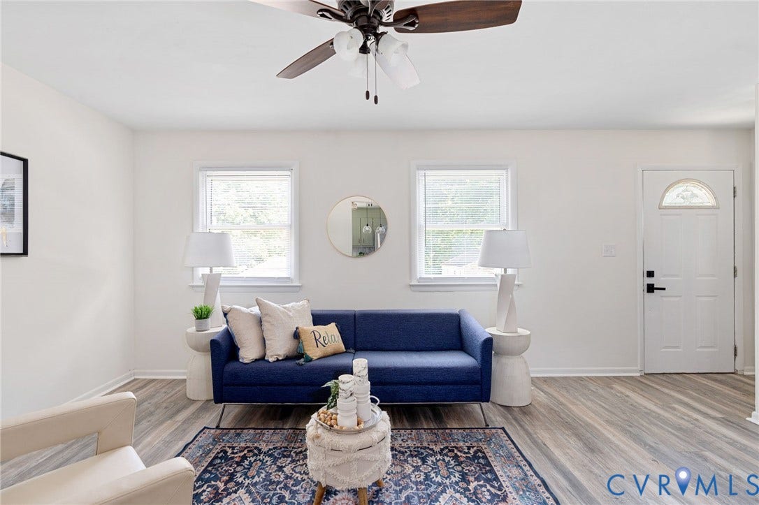 Wood-finish flooring, white walls, and a ceiling fan with integrated lighting