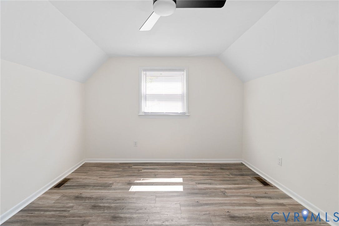 Vaulted ceiling, ceiling fan, wood-finish flooring, white window blinds, and white trim