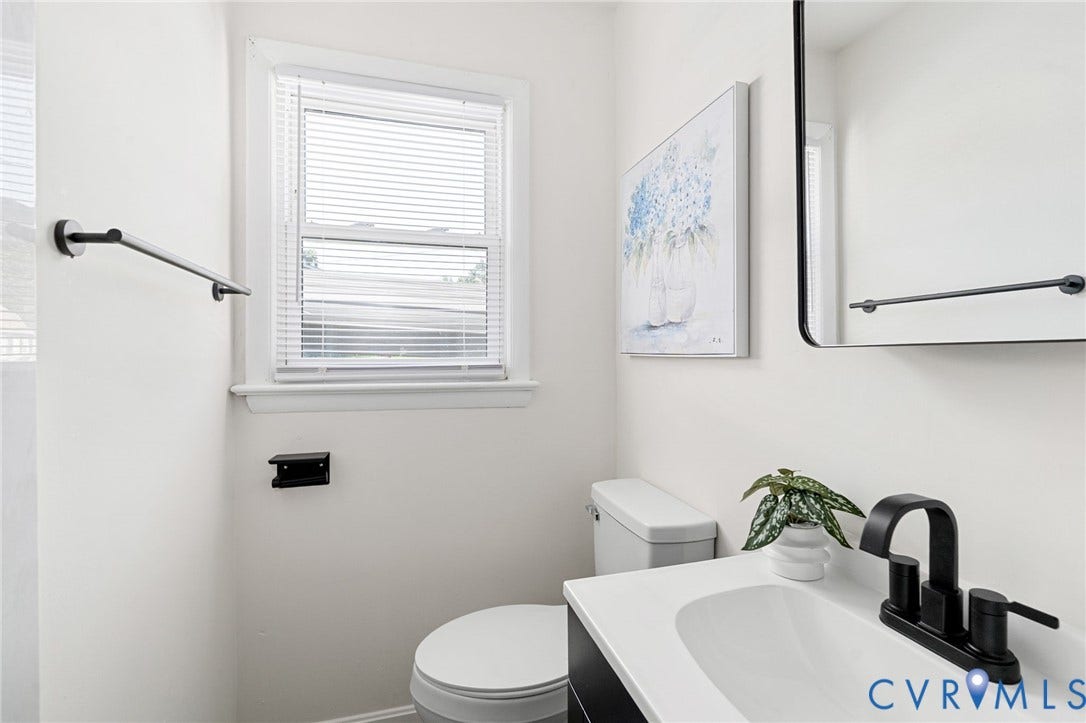 White vanity with integrated sink, matte black faucet, and coordinating matte black towel bar