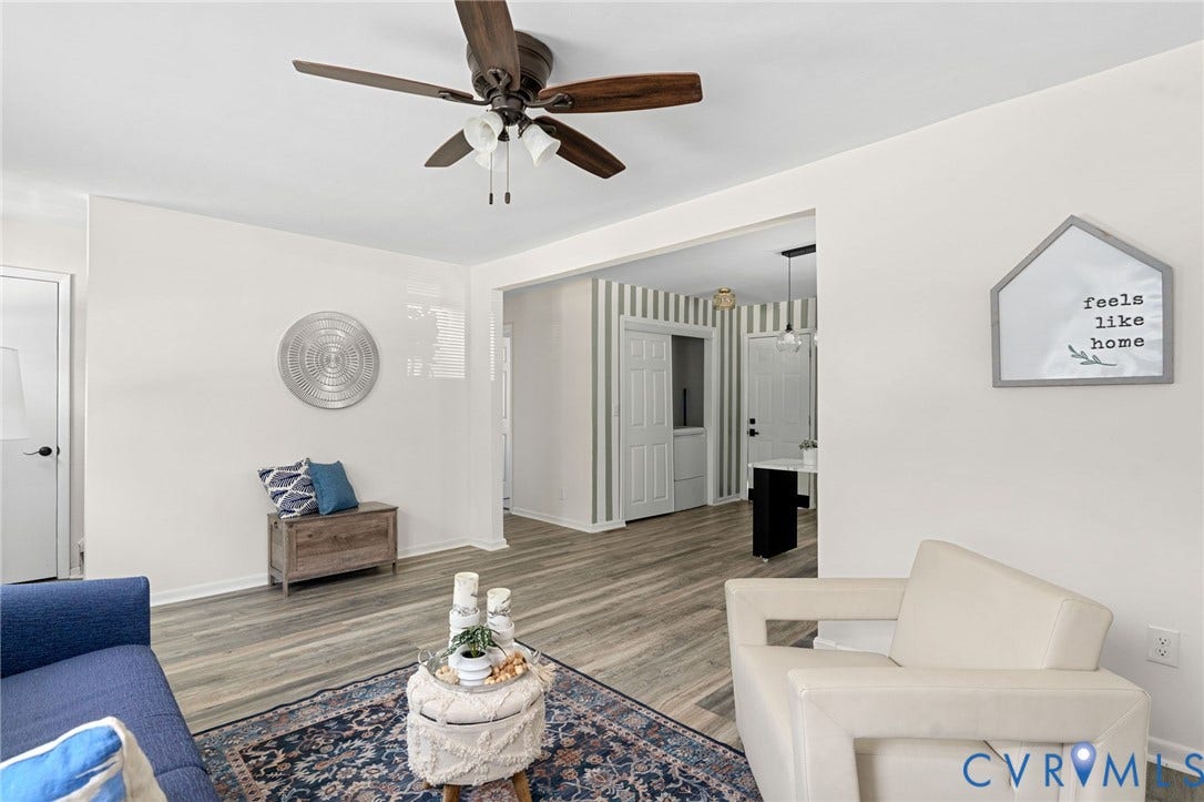 Hardwood-style flooring throughout, ceiling fan with integrated lighting, and a defined entryway