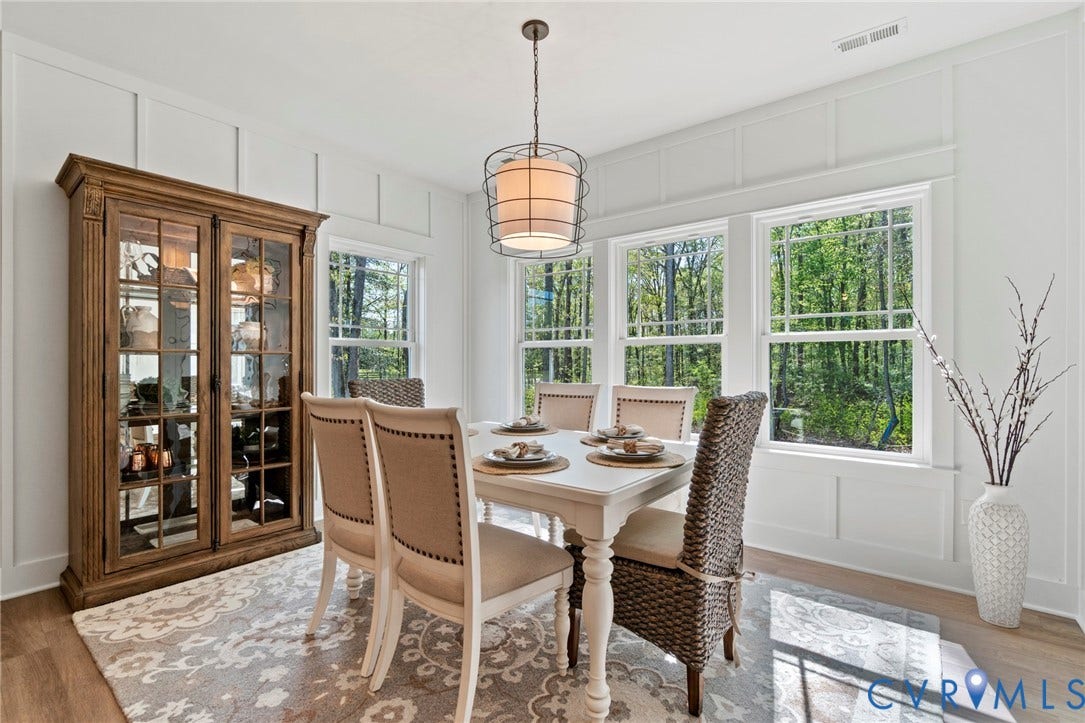 9143 Terroir Lane, Villas, New Kent, VA 23124 Wood-finish flooring with three large windows, white paneled walls, and a drum pendant light fixture