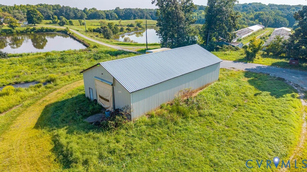 21 Vanderpool Lane, Detached, Cumberland, VA 23040 Large metal outbuilding with a roll-up door, positioned on a grassy incline