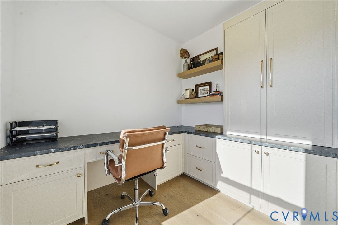 9169 Terroir Lane, Villas, New Kent, VA 23124 Corner desk with a dark countertop, light wood-finish flooring, built-in cabinetry, and integrated shelving