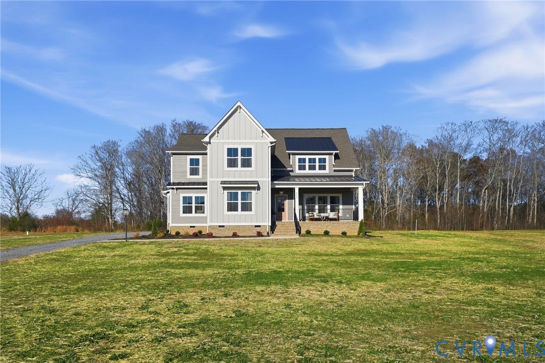 9169 Terroir Lane, Villas, New Kent, VA 23124 Two-story residence featuring light gray siding, dark gray trim, a covered front porch, and solar panels on the roof