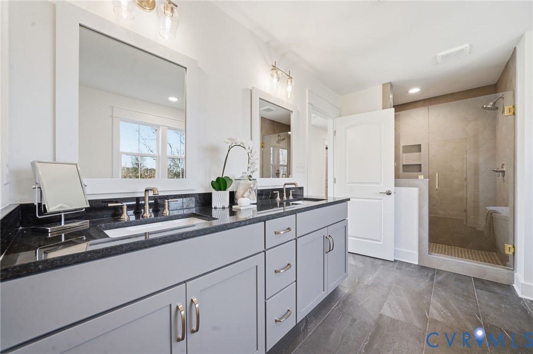 9169 Terroir Lane, Villas, New Kent, VA 23124 Double vanity with a dark stone countertop, undermount sinks, and brushed nickel fixtures
