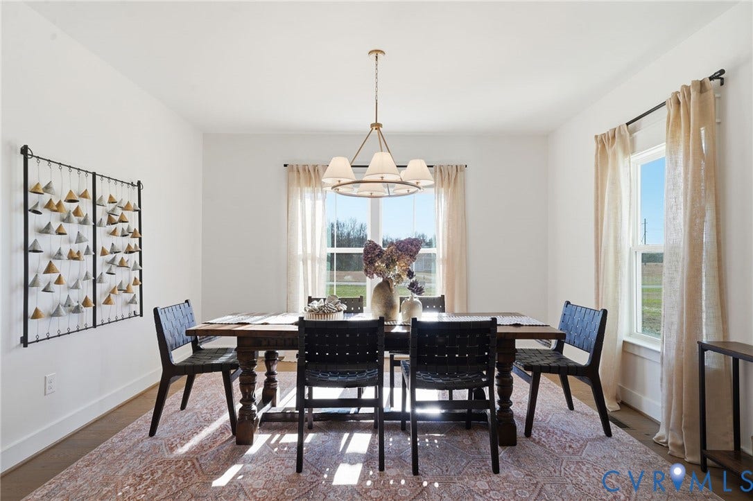 9169 Terroir Lane, Villas, New Kent, VA 23124 Bright interior space featuring a dark wood-finish dining table with substantial turned legs, an elegant chandelier with drum shades, and two large windows