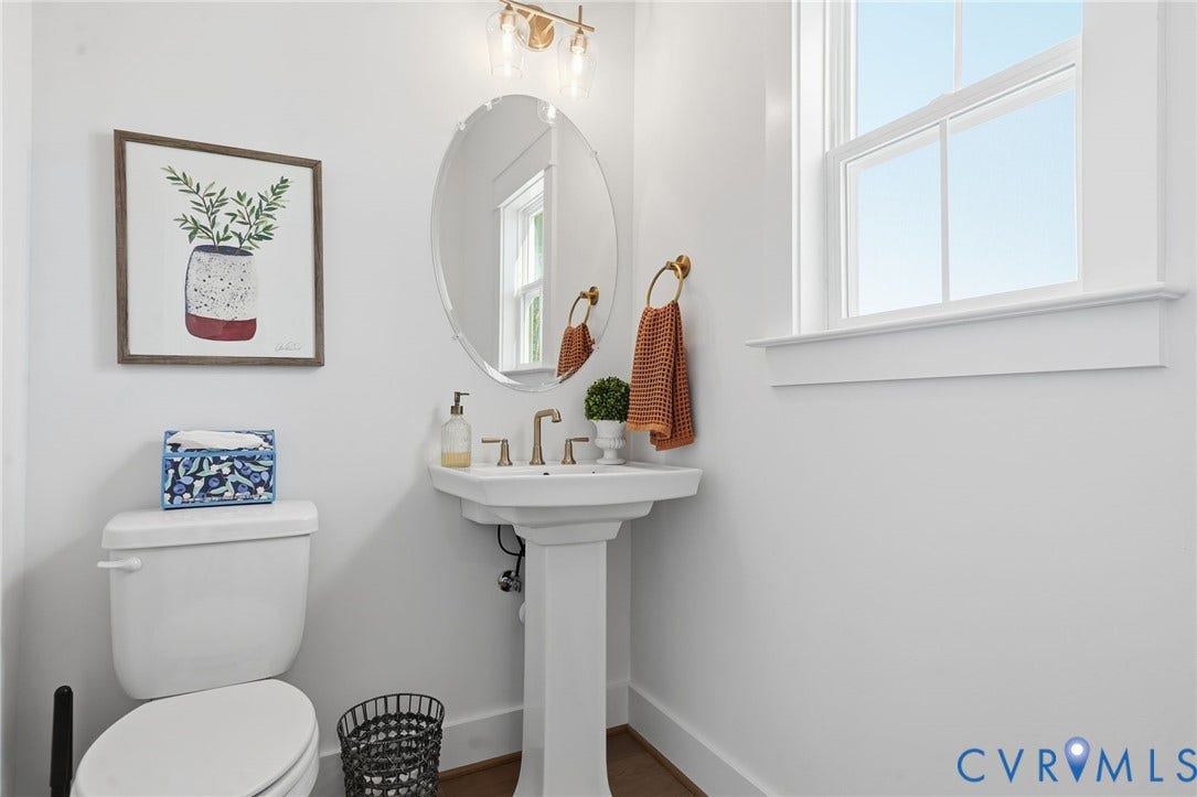 9169 Terroir Lane, Villas, New Kent, VA 23124 Pedestal sink with brass-finish faucet, elongated toilet, oval mirror, and window with white trim