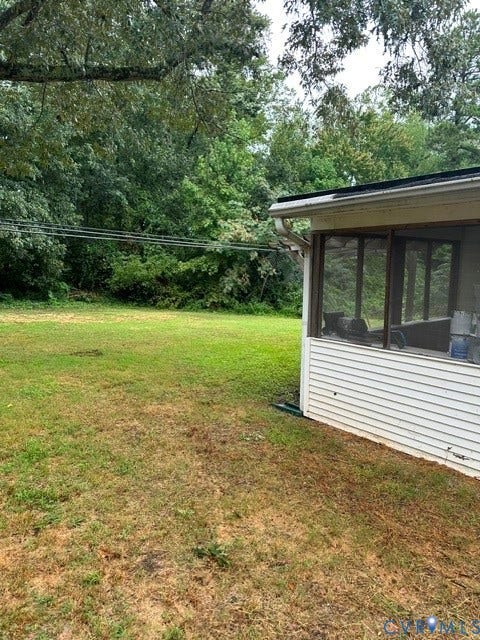 7617 Sunny Bank Drive, Henrico, VA 23228 Expansive grassy area with mature perimeter trees, featuring a screened-in porch with white siding and a dark roofline