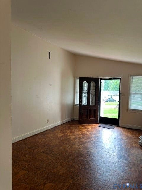 7617 Sunny Bank Drive, Henrico, VA 23228 Vaulted ceiling, wood-finish flooring, dark wood entry door with decorative glass inserts, and multiple windows providing natural light