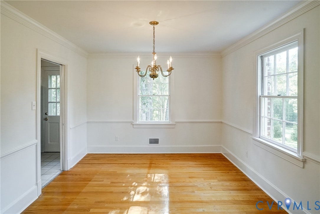 1407 W Monmouth Court, Henrico, VA 23238 Sunny dining room with hardwood flooring, two large windows, brass chandelier, crown molding, and wainscoting