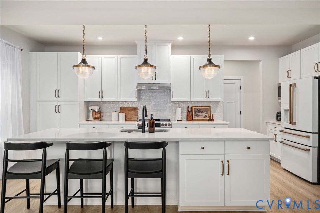 1961 Enon Station Drive, Chester, VA 23836 Expansive kitchen island with a light-toned countertop, white cabinetry with bronze hardware, stainless steel appliances, and wood-finish flooring