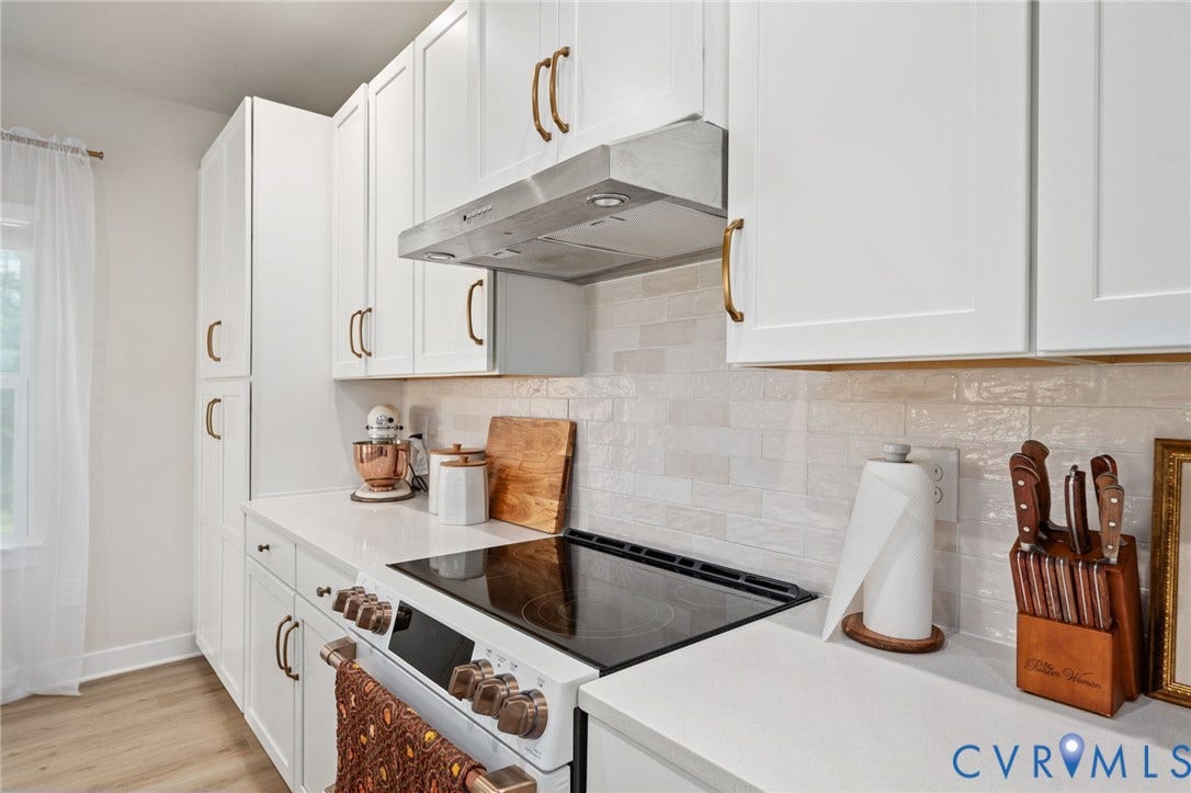 1961 Enon Station Drive, Chester, VA 23836 White shaker-style cabinetry with gold-tone hardware, a tiled backsplash, built-in range, and wood-finish flooring