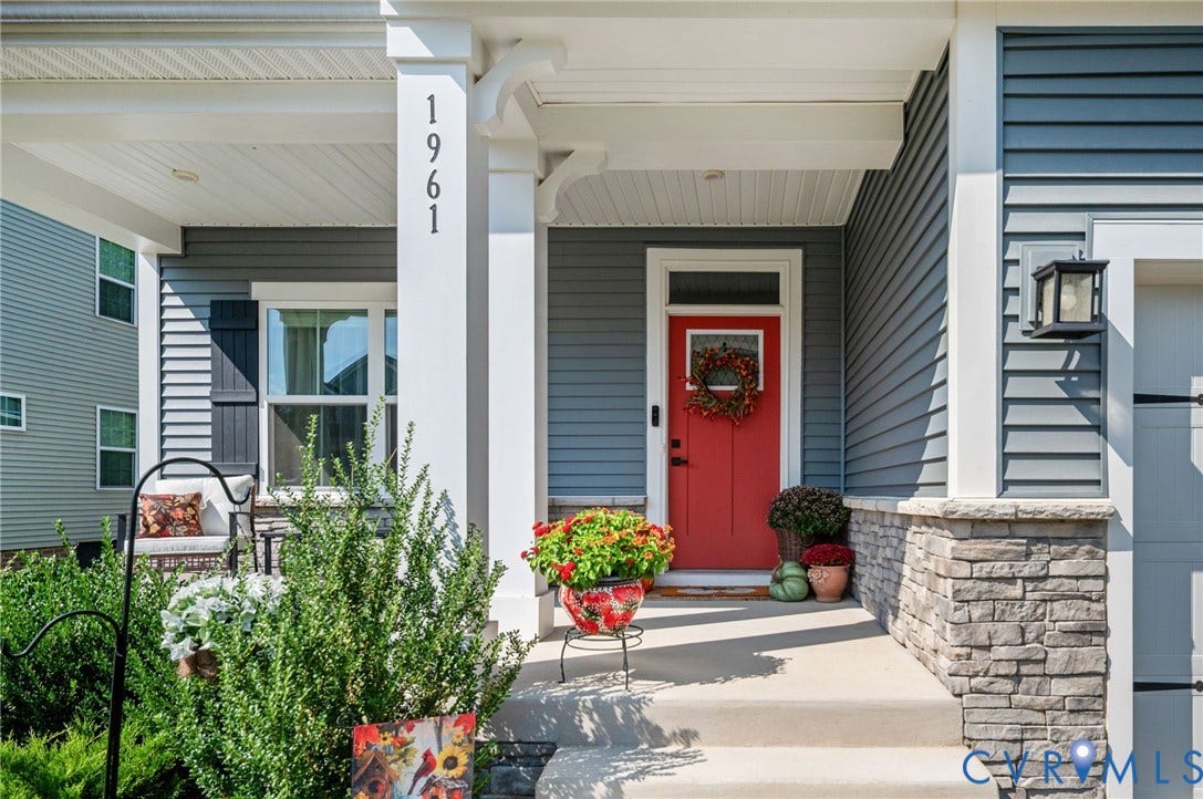 1961 Enon Station Drive, Chester, VA 23836 Covered front porch with stone accents, gray horizontal siding, and an opaque red door