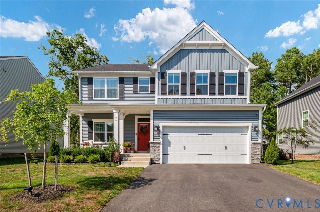 1961 Enon Station Drive, Chester, VA 23836 Two-story siding exterior with stone accents, covered front porch, attached garage, and paved driveway