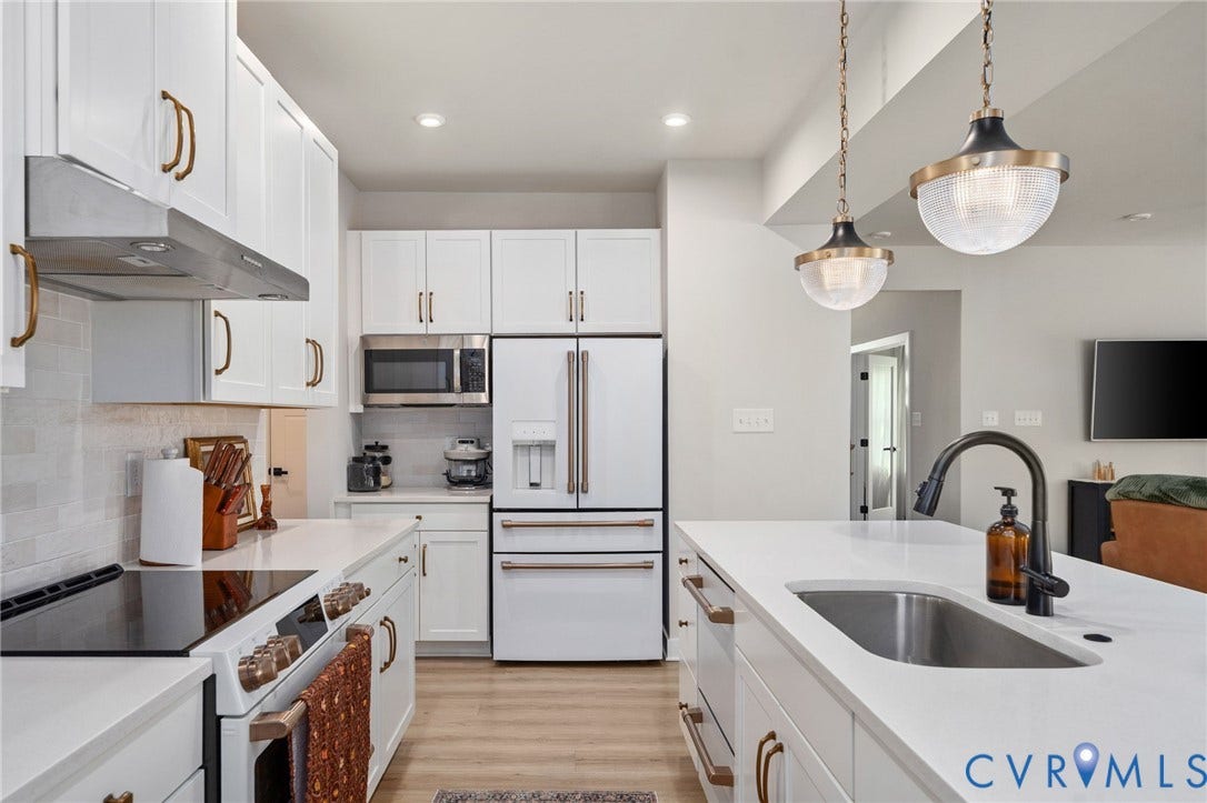 1961 Enon Station Drive, Chester, VA 23836 Kitchen featuring white cabinetry, integrated appliances, an island with an undermount sink, pendant lighting, and wood-finish flooring