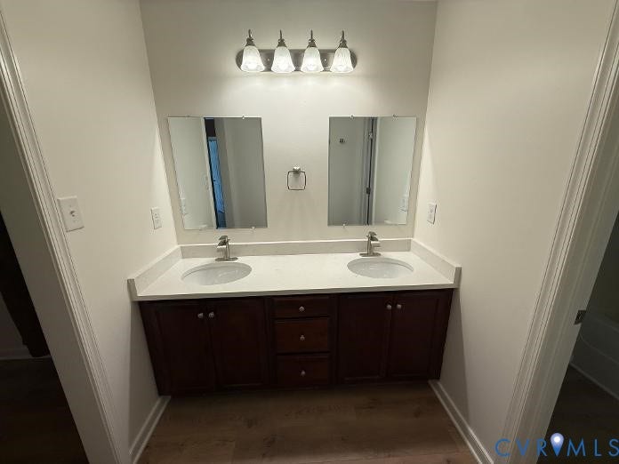 289 Winding Ridge Way, Winding Ridge, Bumpass, VA 23024 Dual vanity with white undermount sinks, stone-finish countertop, dark wood-finish cabinetry, and chrome fixtures