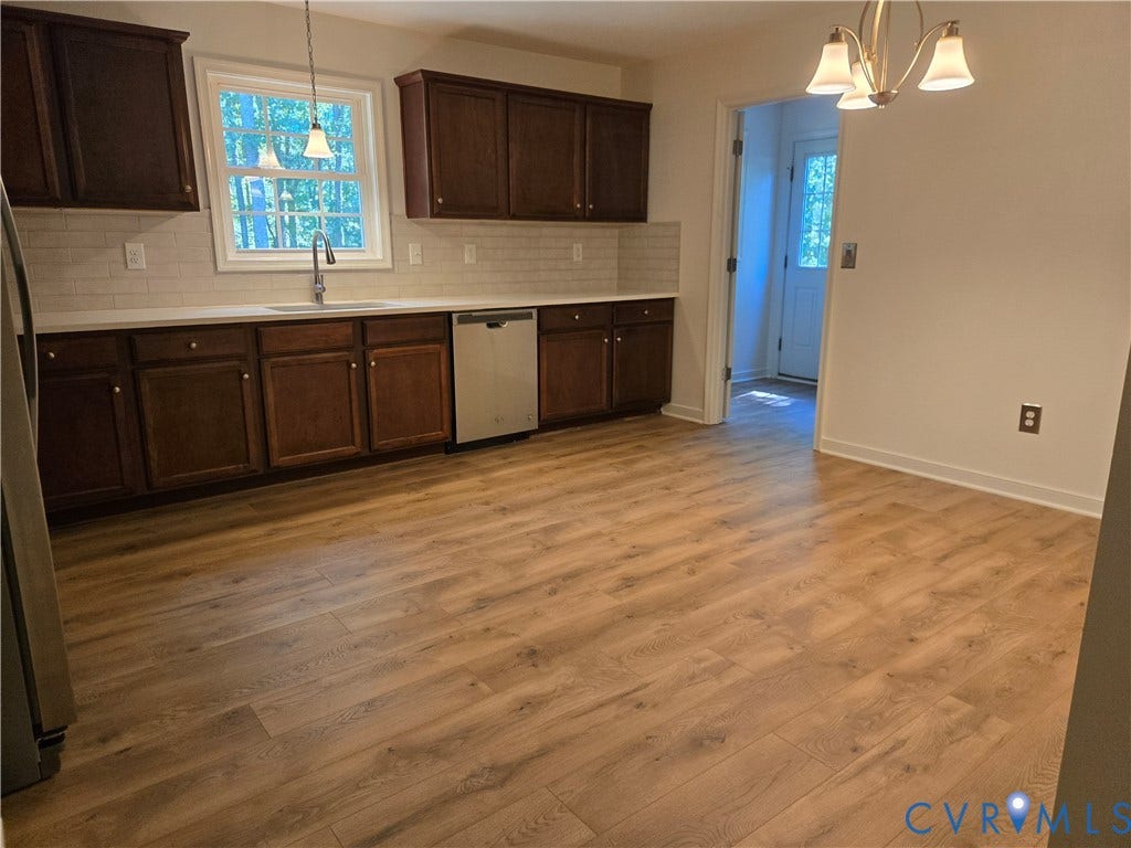 289 Winding Ridge Way, Winding Ridge, Bumpass, VA 23024 Kitchen with wood-finish flooring, dark wood cabinetry, light-toned countertops, and a subway tile backsplash