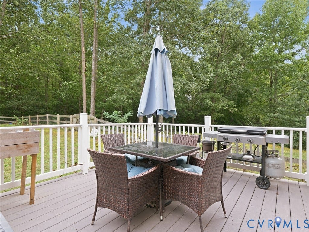 8325 Caroline Vines Way, Estates At Willis Church, Henrico, VA 23231 Spacious outdoor deck with a light gray surface, white railing, and a natural tree-lined backdrop