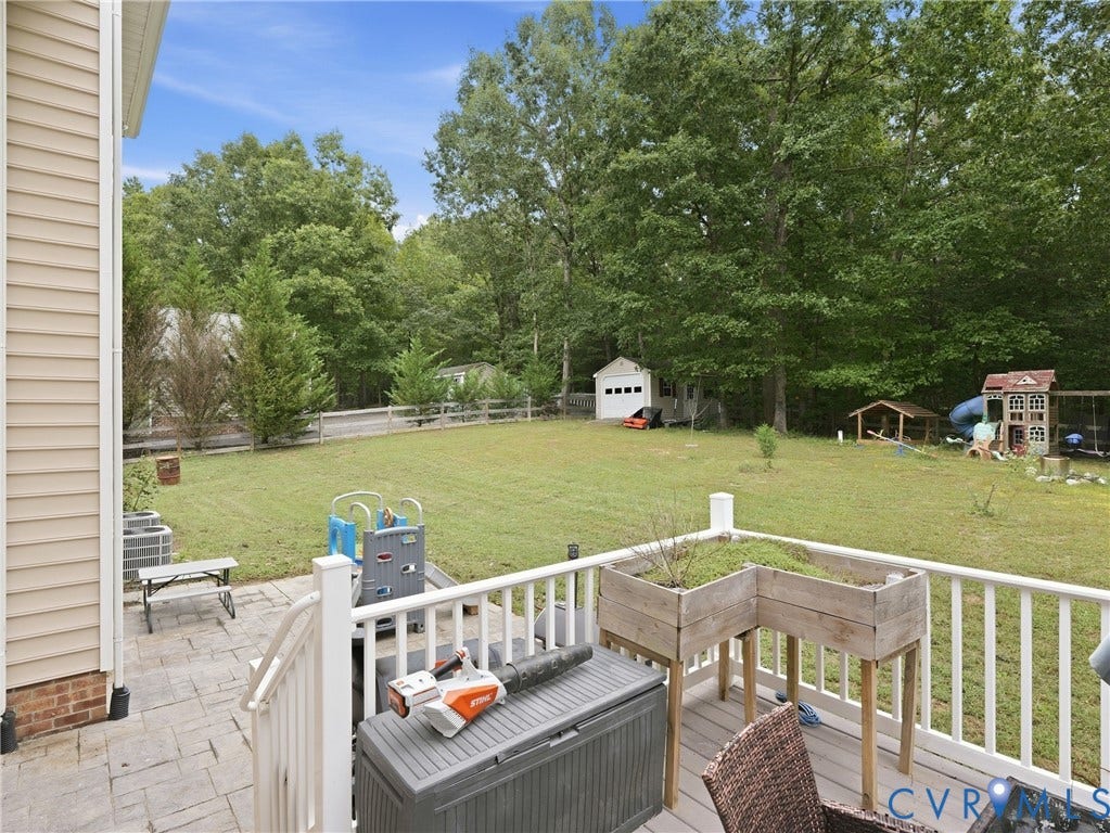 8325 Caroline Vines Way, Estates At Willis Church, Henrico, VA 23231 Expansive backyard with a manicured lawn, established trees, and a storage shed