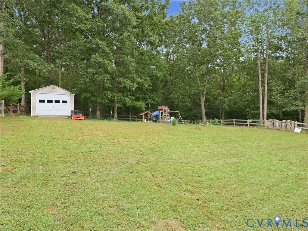 8325 Caroline Vines Way, Estates At Willis Church, Henrico, VA 23231 Expansive lawn area, storage shed with a roll-up garage door, and a split-rail fence