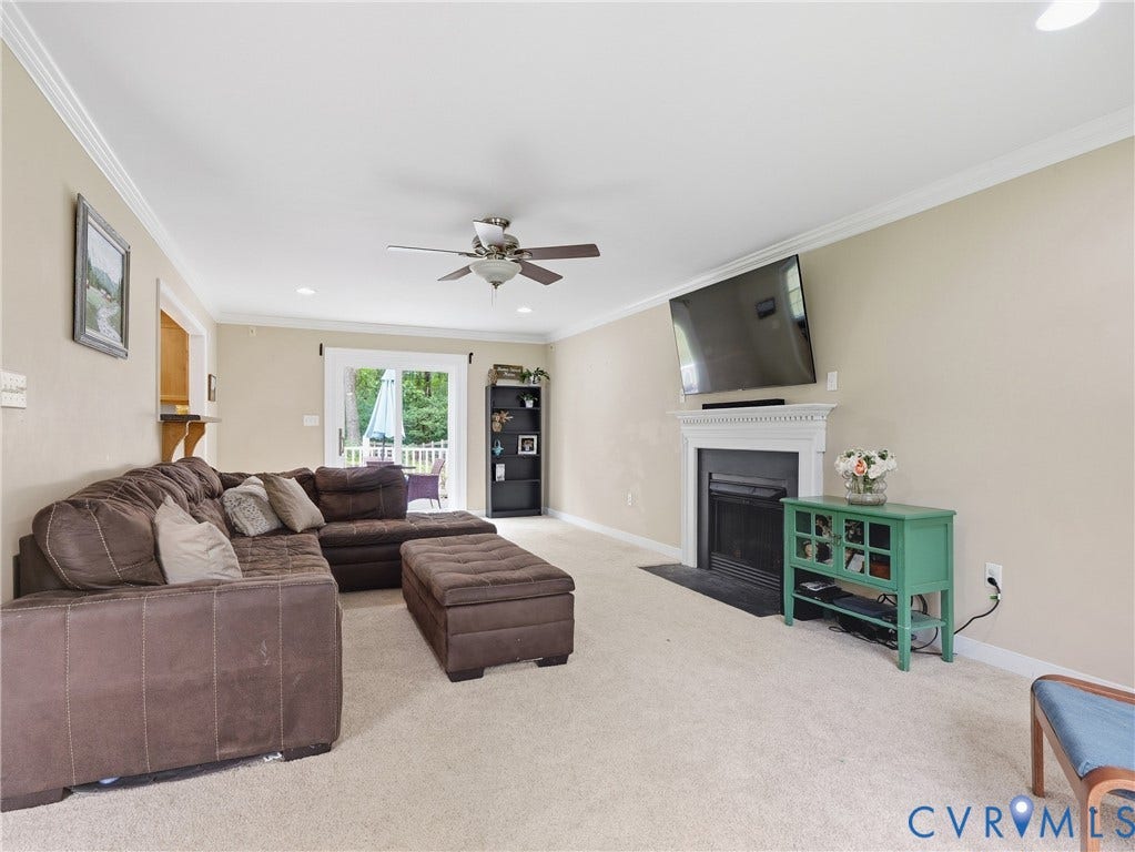 8325 Caroline Vines Way, Estates At Willis Church, Henrico, VA 23231 Living area featuring a fireplace with a mantel, ceiling fan, crown molding, and sliding glass door