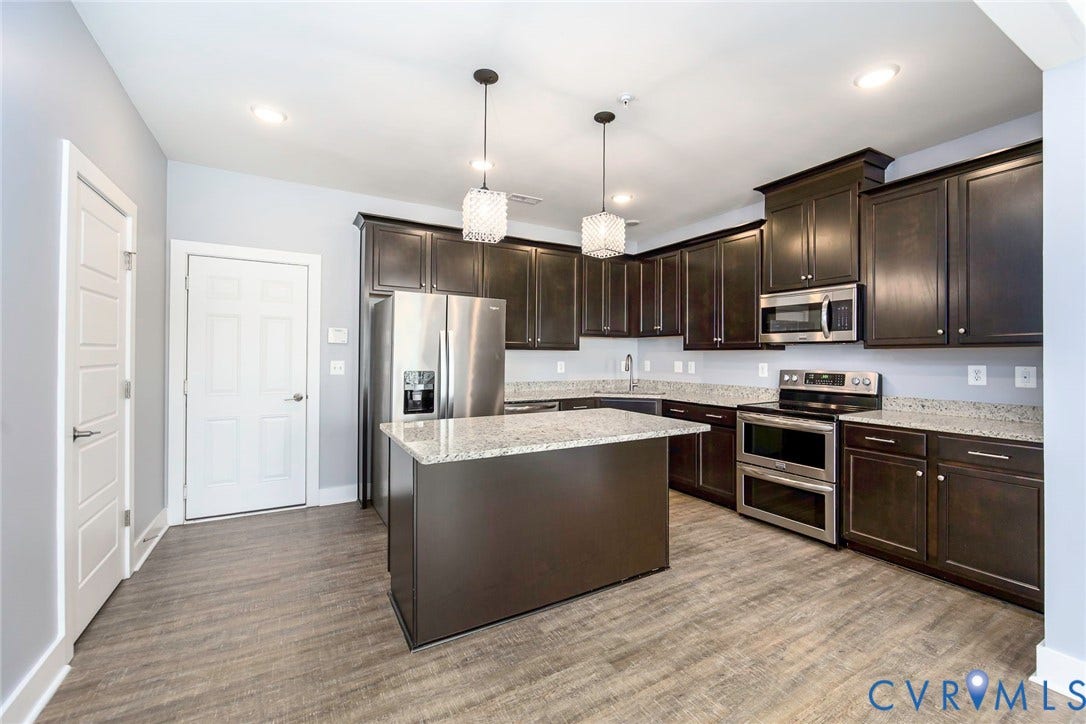 4300 Bon Secours Parkway, #A, Henrico, VA 23233 Kitchen featuring dark wood-finish cabinetry, granite countertops, stainless steel appliances, a central island, and wood-finish flooring
