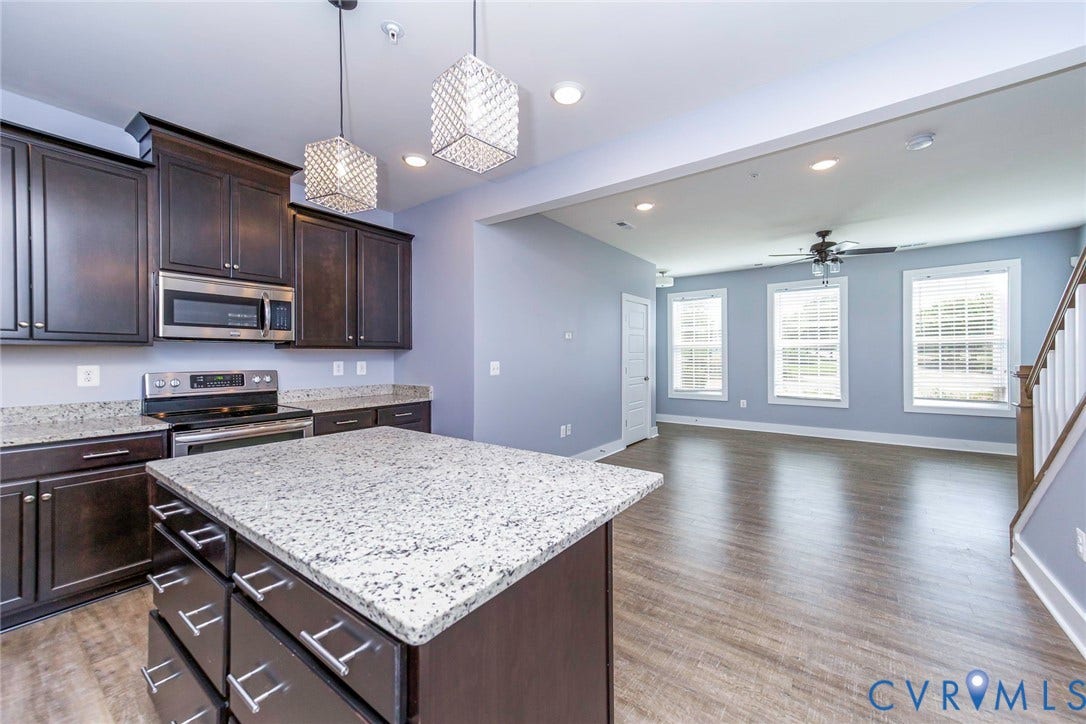 4300 Bon Secours Parkway, #A, Henrico, VA 23233 Kitchen featuring dark wood cabinetry, stainless steel appliances, and a central island with a light-toned countertop