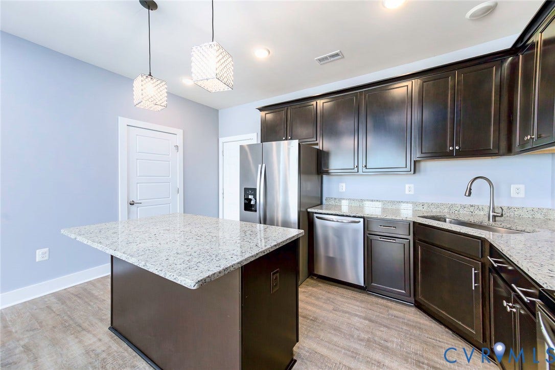 4300 Bon Secours Parkway, #A, Henrico, VA 23233 Kitchen featuring an island with stone countertop, stainless steel appliances, dark wood-finish cabinetry, wood-finish flooring, and pendant lighting