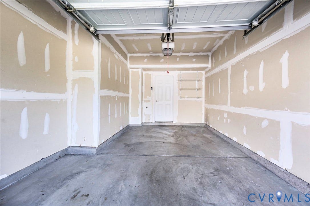 4300 Bon Secours Parkway, #A, Henrico, VA 23233 Garage space with concrete flooring, drywall-ready walls, and an overhead garage door mechanism