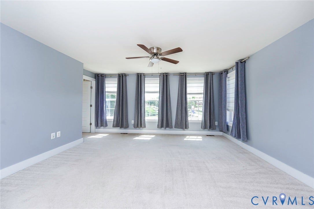 4300 Bon Secours Parkway, #A, Henrico, VA 23233 Expansive room featuring light-colored carpeting, multiple windows with blinds, a ceiling fan, and a light blue wall finish