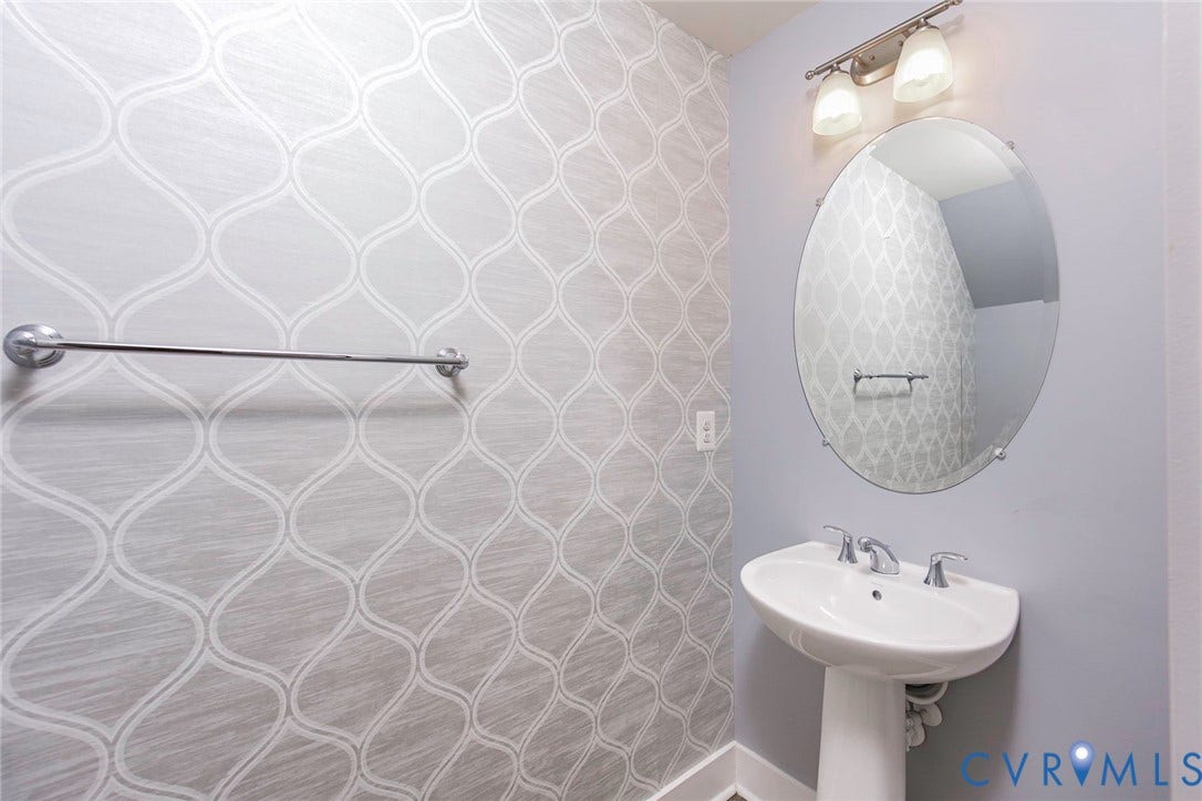 4300 Bon Secours Parkway, #A, Henrico, VA 23233 Pedestal sink with chrome faucet, oval mirror, and wall-mounted lighting