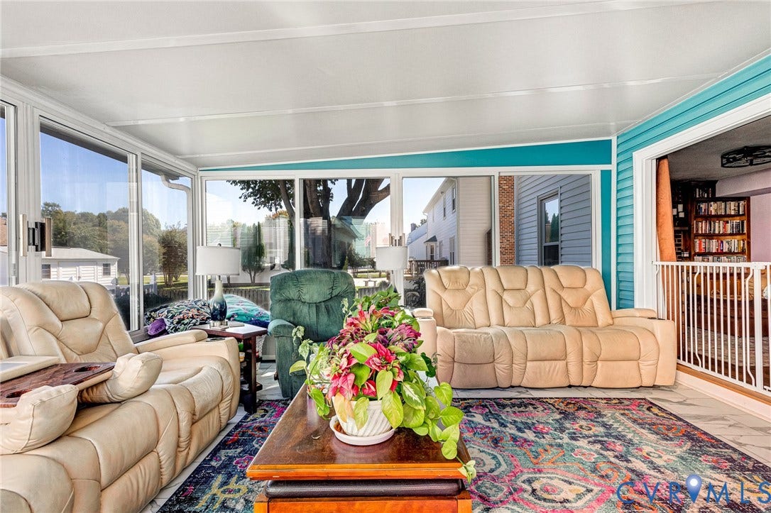 Sunroom with expansive windows, a white ceiling, and a blue accent wall