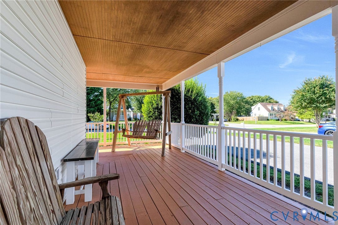 Covered front porch featuring wood-finish flooring, white siding, beadboard ceiling, and white railing