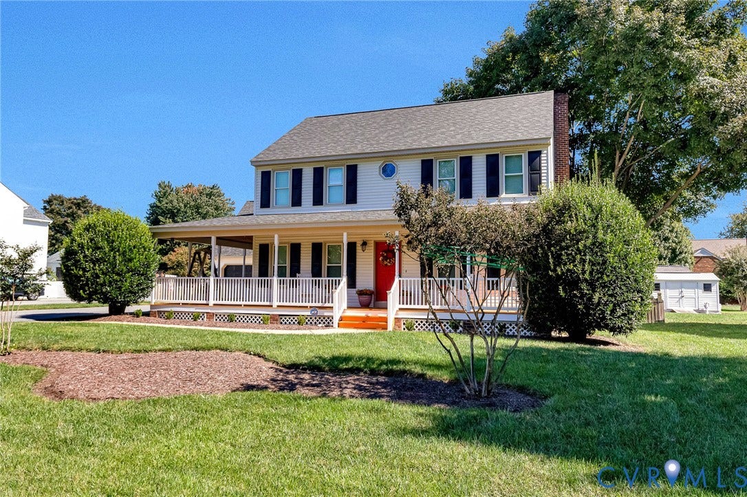 Two-story residence featuring white siding, a covered front porch with white railings, and a red front door