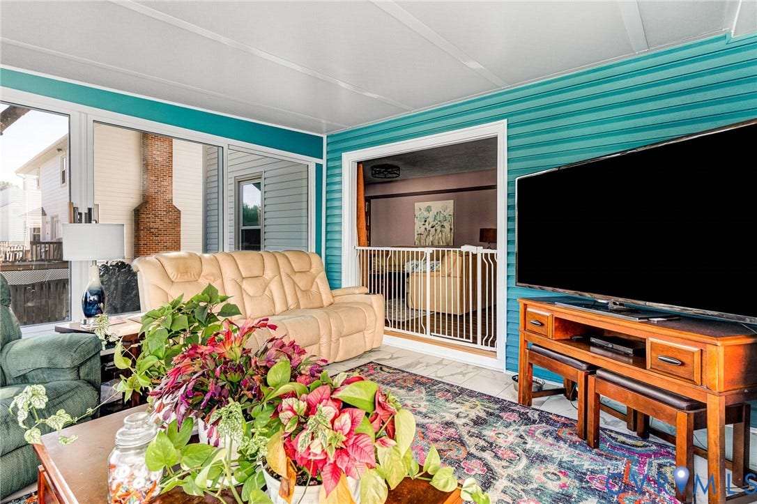 Enclosed sunroom featuring multiple windows, teal paneled walls, and a white paneled ceiling