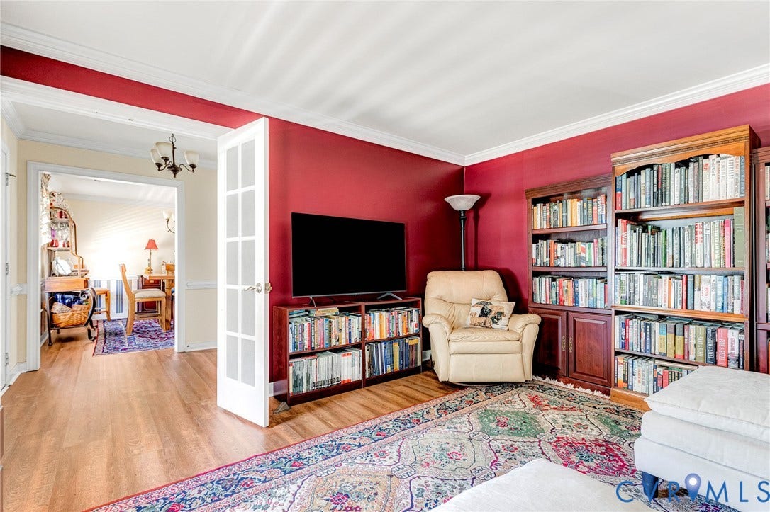 Wood-finish flooring, built-in shelving, crown molding, and French doors