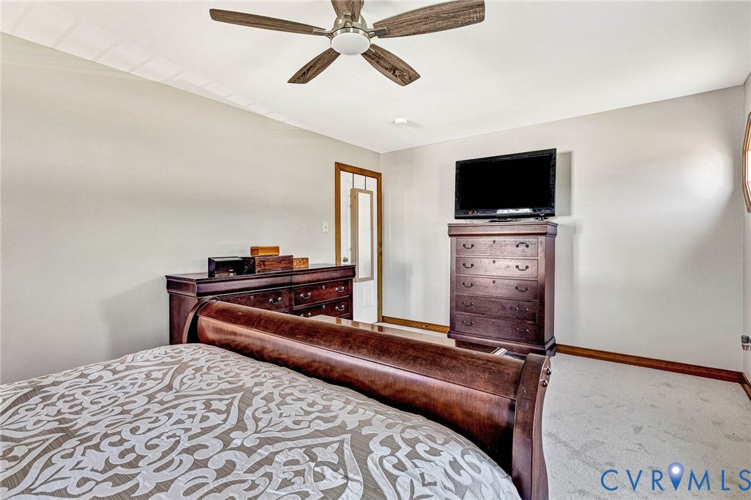 Ceiling fan with wood-finish blades, recessed ceiling lighting, and light-toned carpet flooring