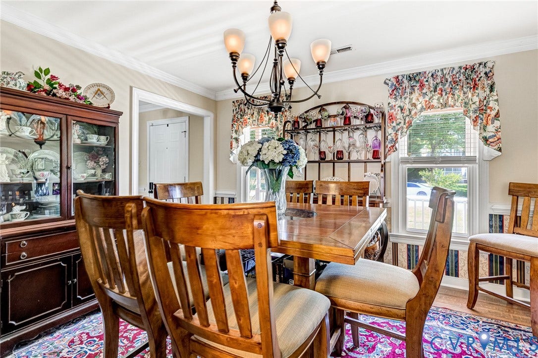 Crown molding, chair rail molding, chandelier, and a large window