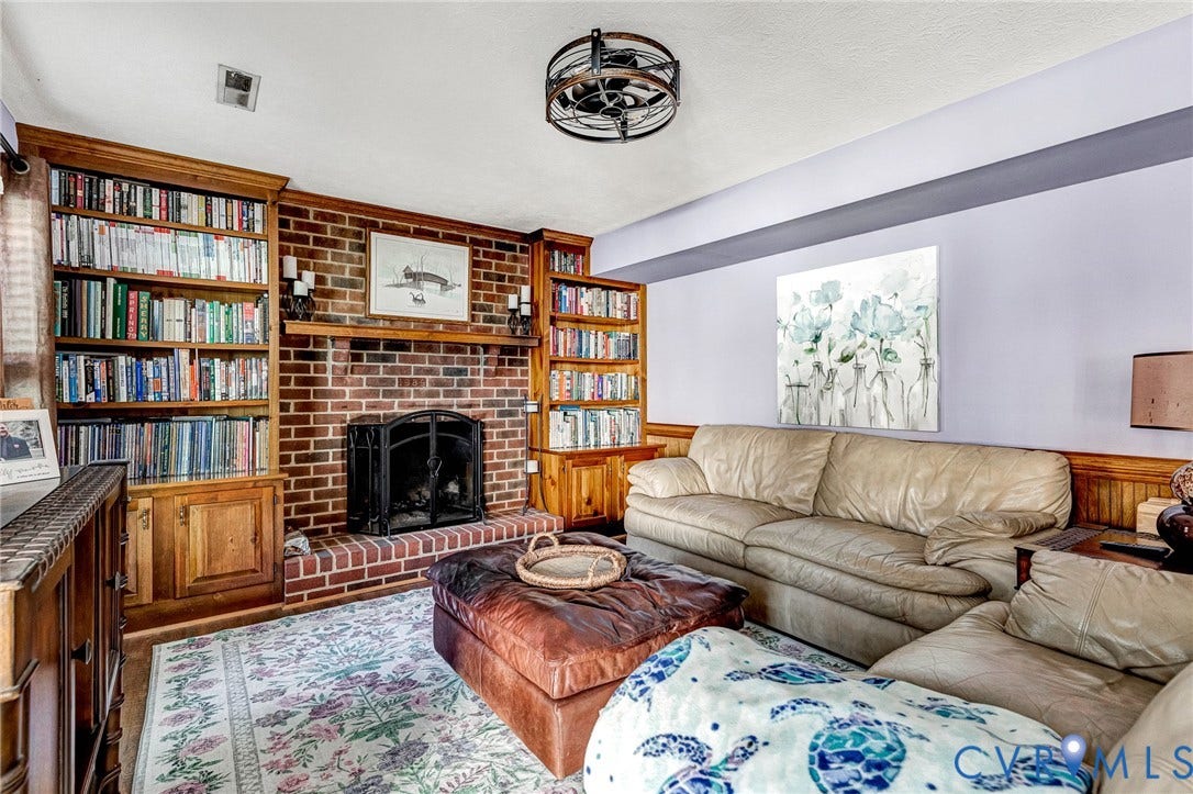 Brick fireplace with a black metal screen, flanked by built-in wood shelving and cabinetry