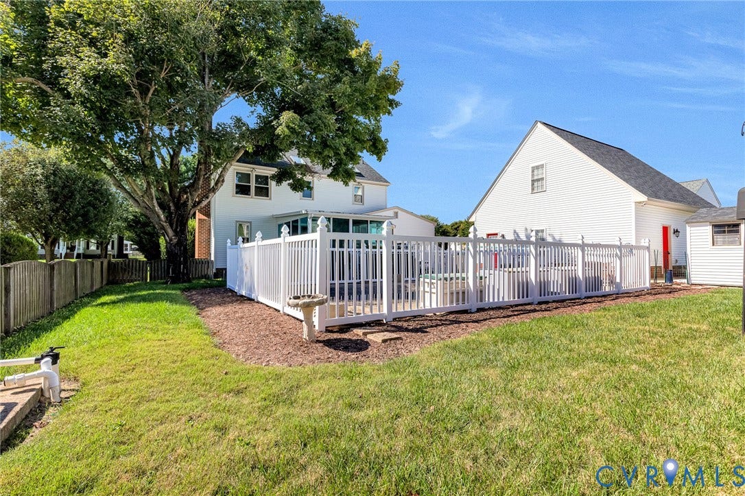 Manicured lawn with a white privacy fence enclosing a patio area
