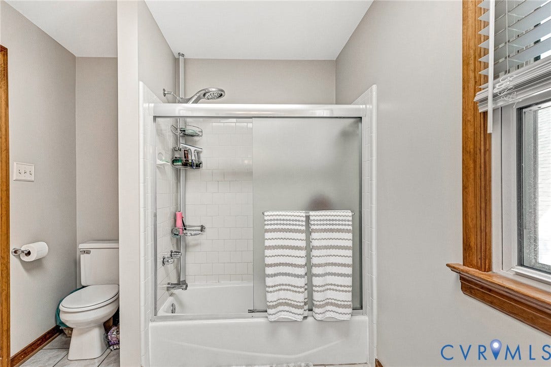 Tub-shower combination with white subway tile surround and sliding glass doors