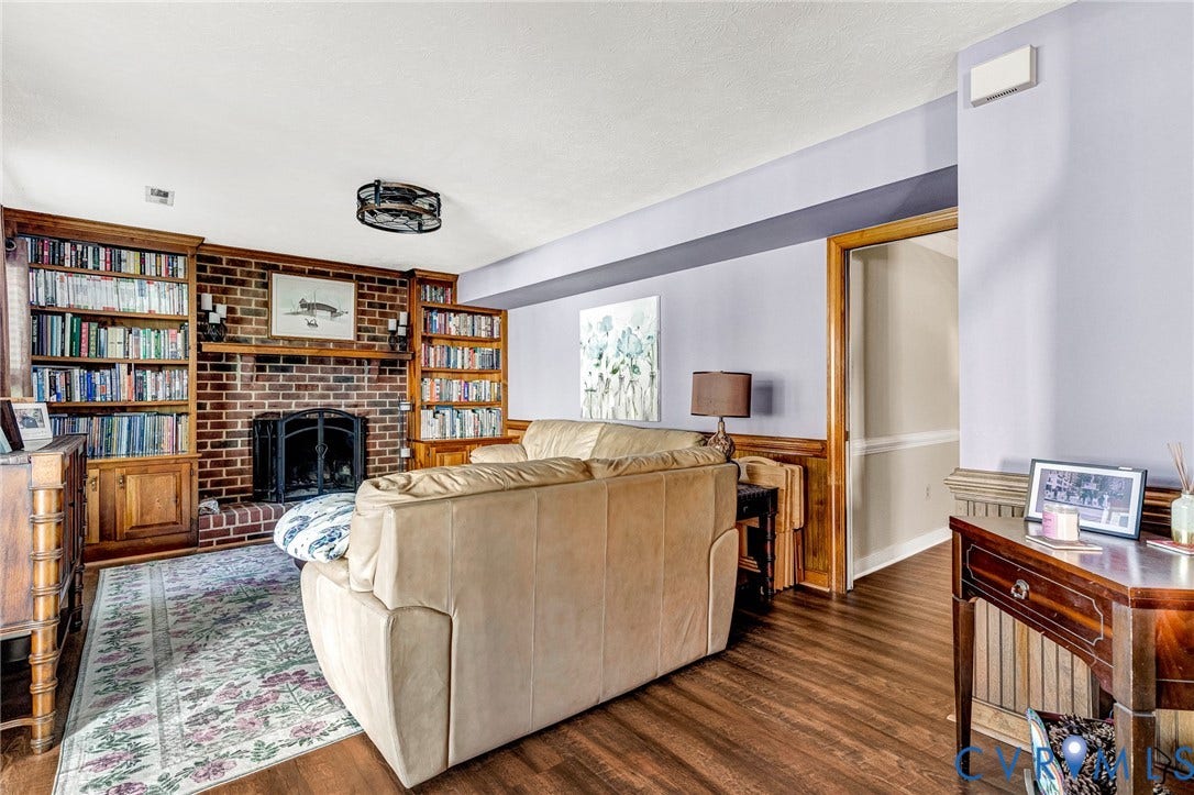 Brick fireplace with a wood mantle, flanked by built-in wood shelving