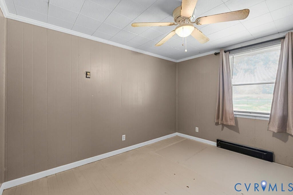 21 Vanderpool Lane, Detached, Cumberland, VA 23040 Room featuring paneling walls, a window with blinds, a ceiling-mounted fan with integrated lighting, and a baseboard heating unit