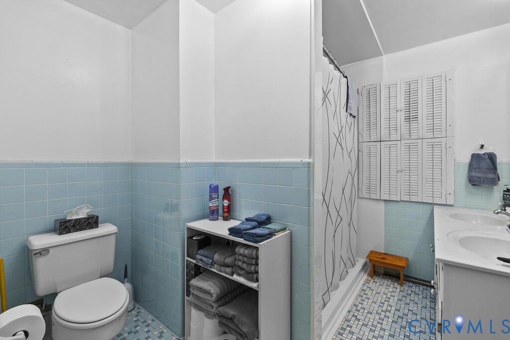 21 Vanderpool Lane, Detached, Cumberland, VA 23040 Bathroom featuring a two-tone wall design, floor-mounted toilet, vanity with dual sinks, and a shower with a privacy curtain