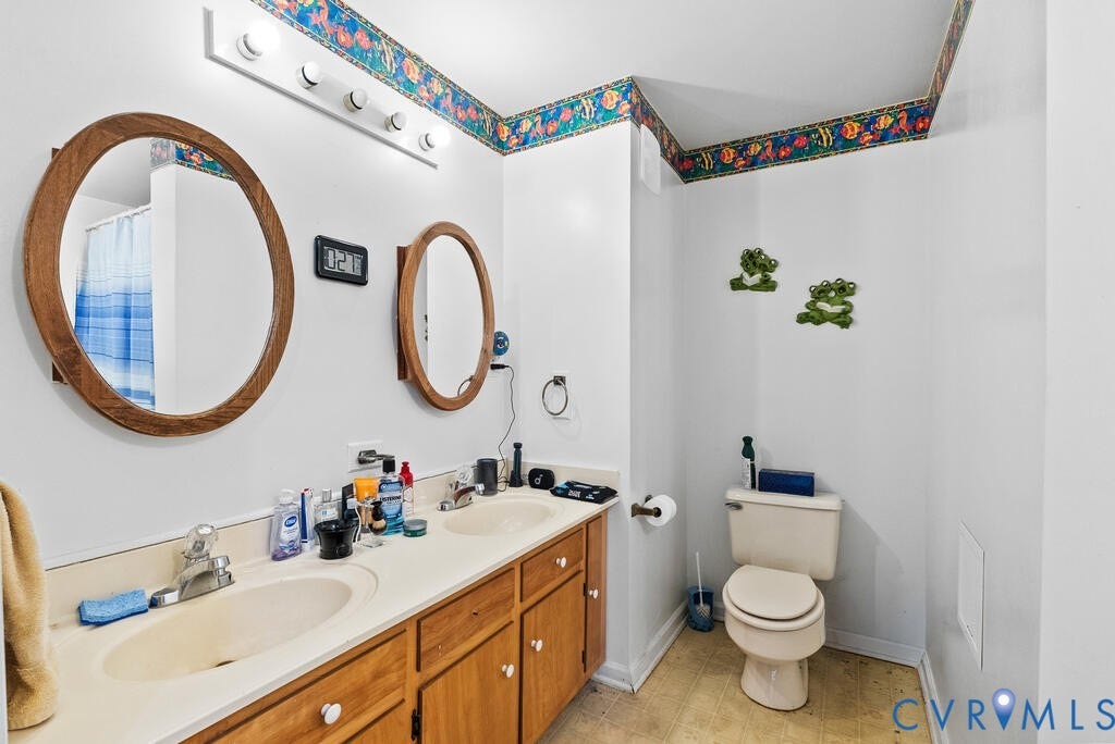 21 Vanderpool Lane, Detached, Cumberland, VA 23040 Dual vanity with integrated sinks, wood-finish cabinetry, and individual oval mirrors