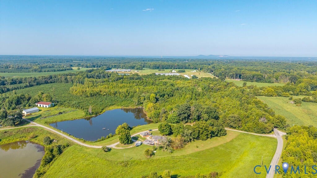 21 Vanderpool Lane, Detached, Cumberland, VA 23040 Expansive rural property featuring multiple ponds, a winding unpaved road, green fields, and surrounding dense foliage