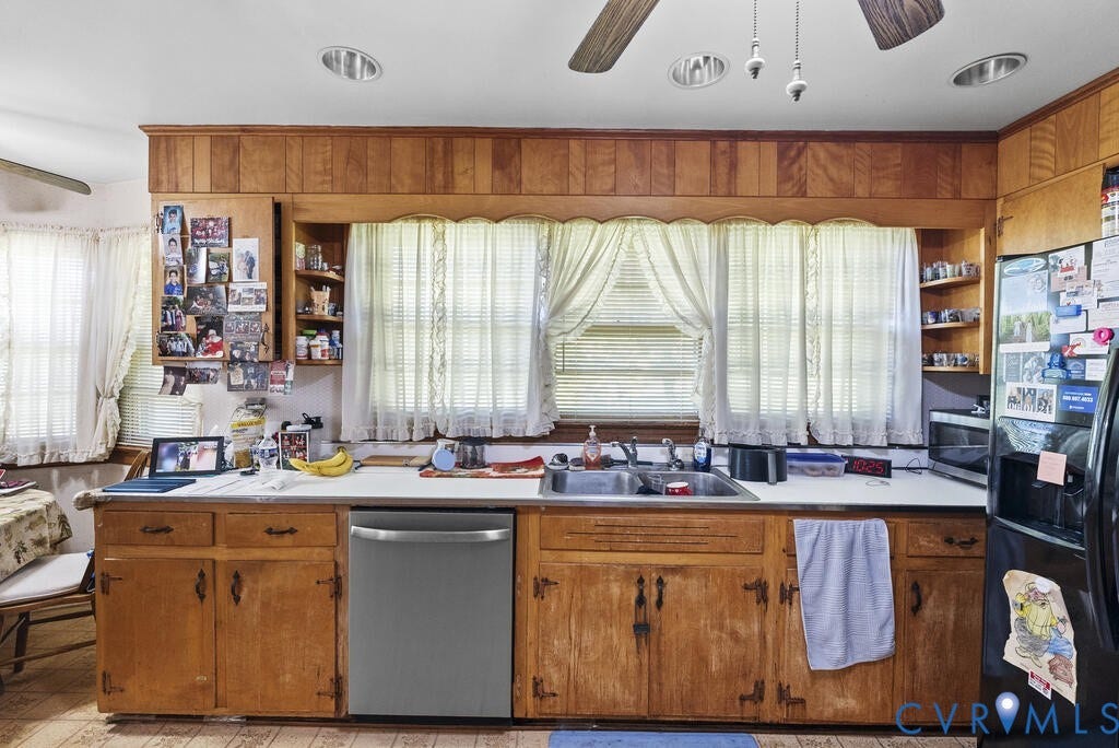 21 Vanderpool Lane, Detached, Cumberland, VA 23040 Spacious kitchen showcasing warm wood cabinetry with ample storage, stainless steel appliances including a dishwasher, wood-finish flooring, and abundant natural light from multiple windows with operable shutters and drapery