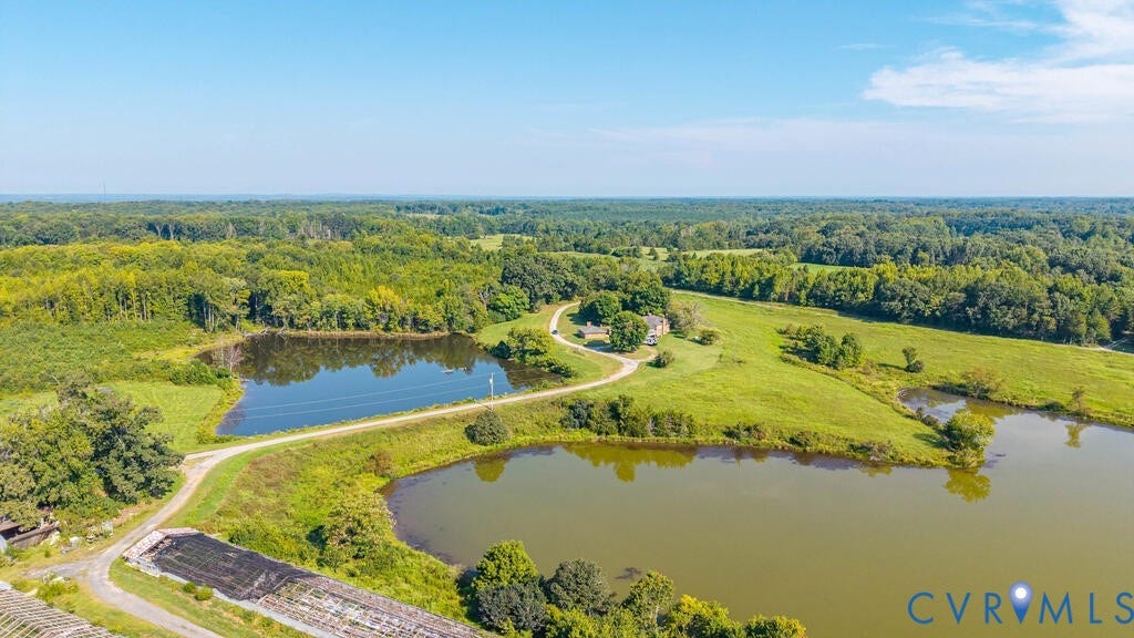 21 Vanderpool Lane, Detached, Cumberland, VA 23040 Expansive property featuring two distinct ponds, a winding unpaved drive, and surrounding natural woodlands