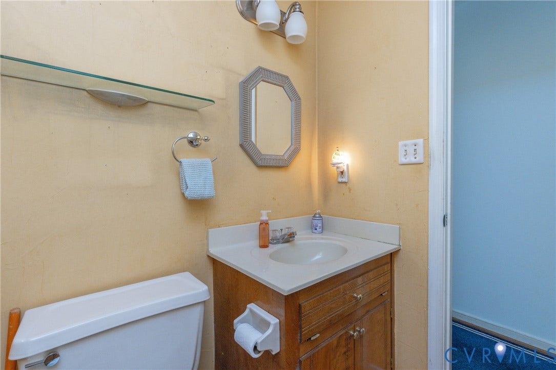 13802 Rockhaven Drive, Thornhill, Chester, VA 23836 Corner vanity with an integrated sink, wood-finish cabinetry, and a light-toned countertop